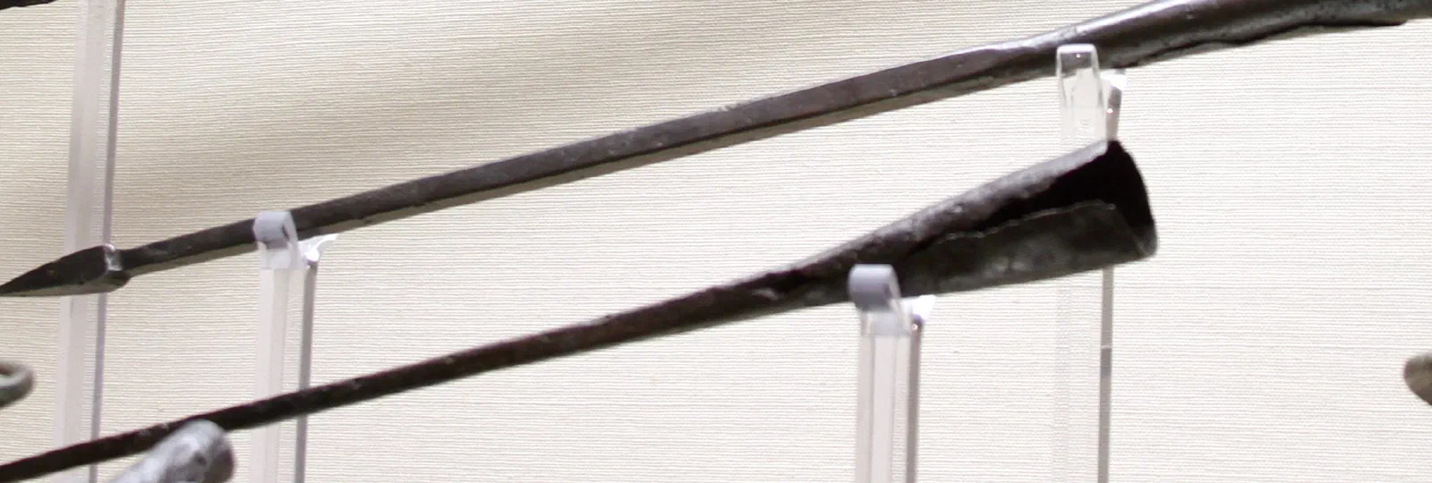 Two ancient Roman pila: long, thin iron shanks ending in small pyramidal points.