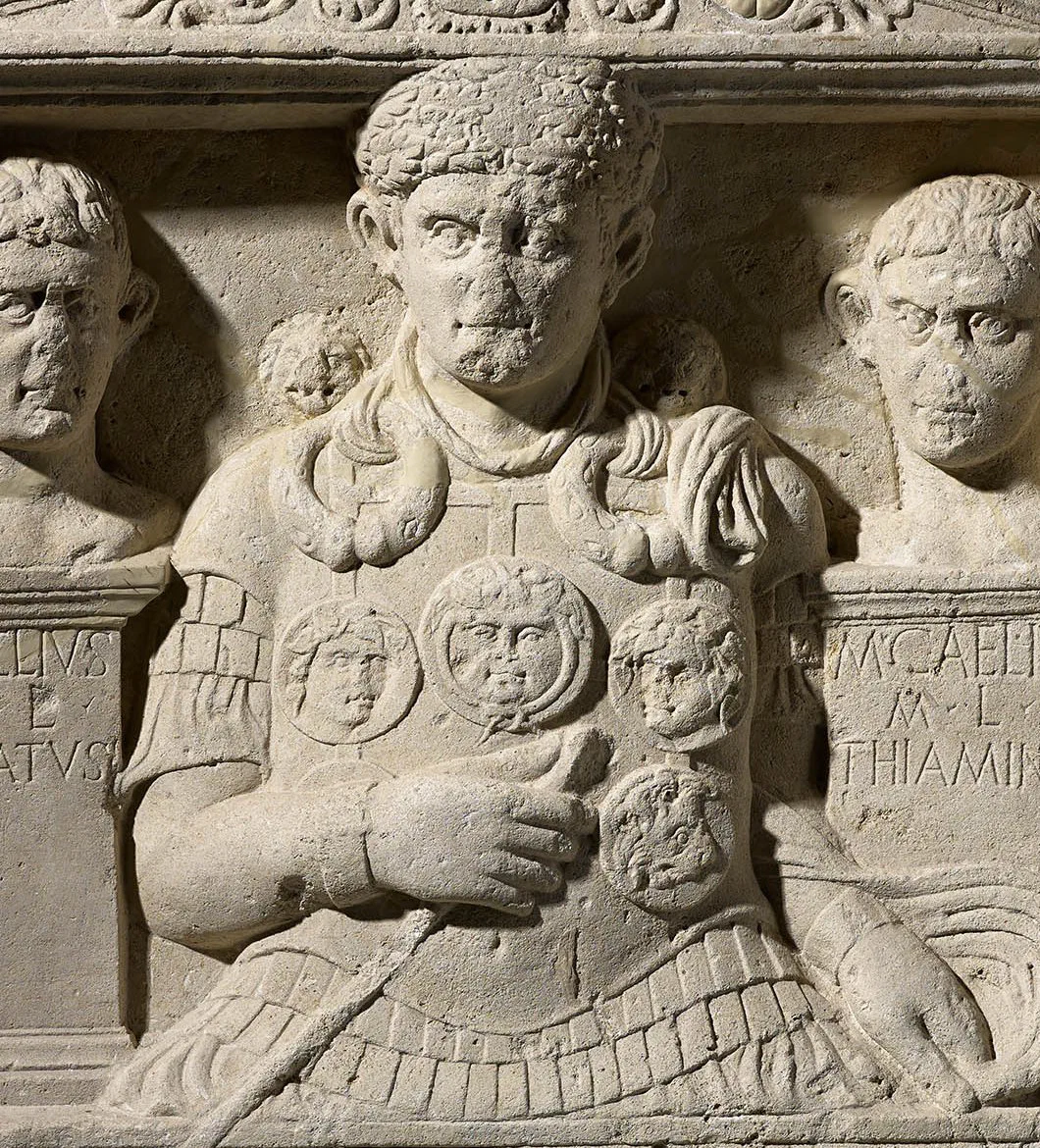 A carved half-length portrait of a Roman officer wearing an oak-leaf crown, neck-rings, arm-bands, and a chest harness of disc medallions.
